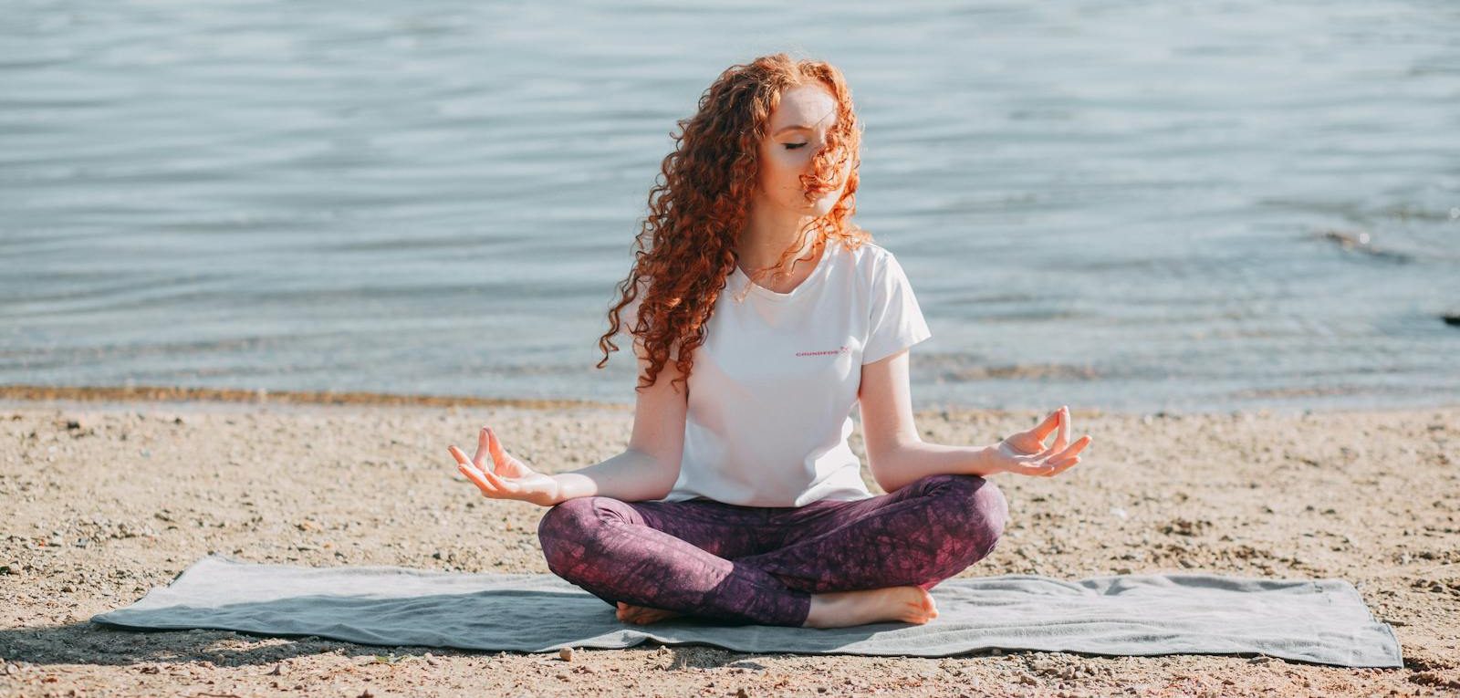 Woman Doing Yoga Exercise At The Sea Shore